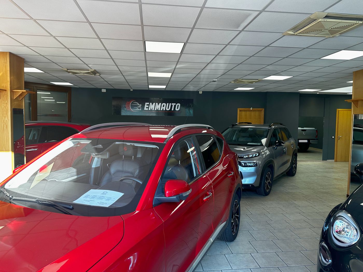 Il salone Emmauto a Dorzano con l'insegna e le auto esposte